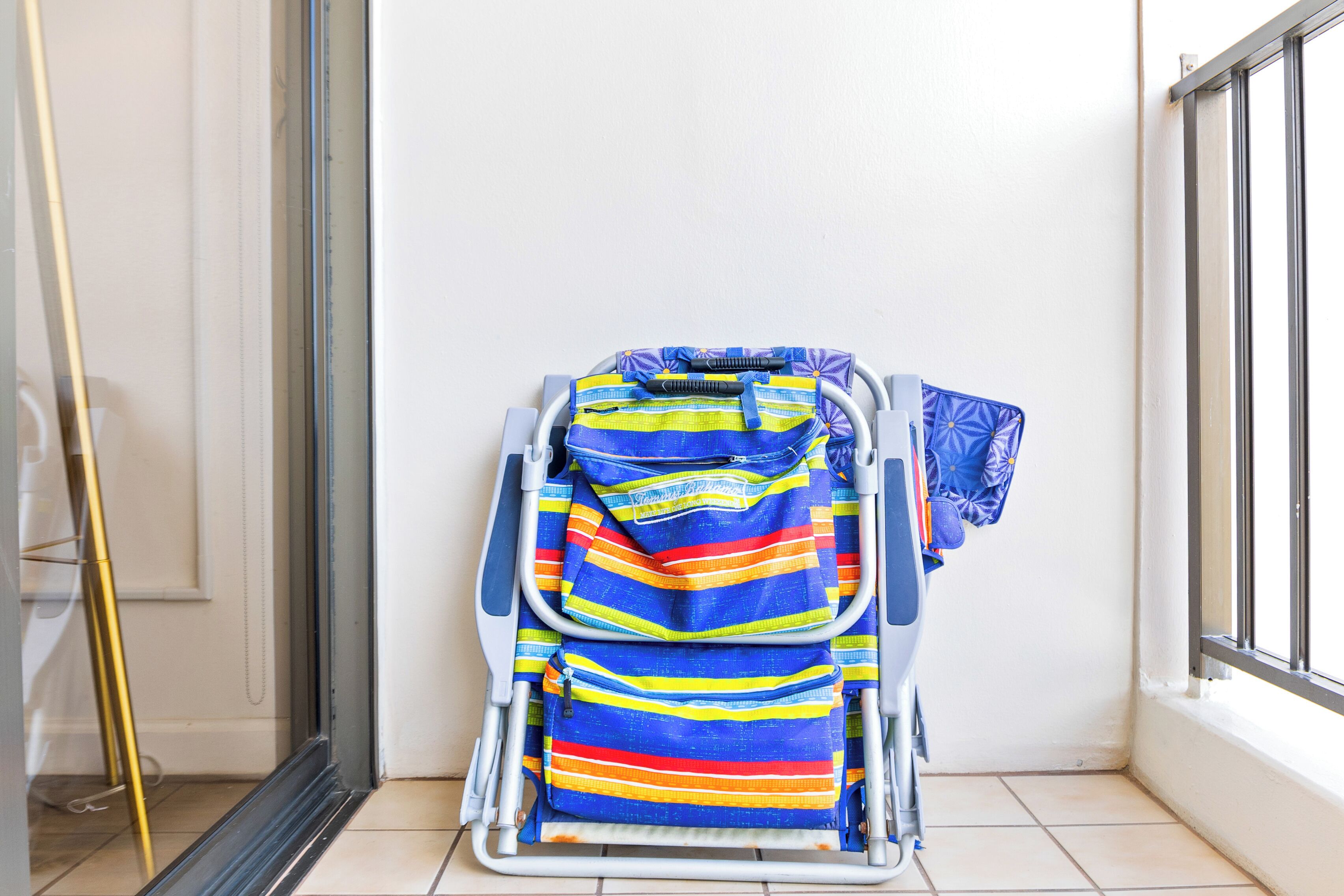 Un fauteuil roulant dans un coin, recouvert de couvertures rayées aux couleurs vives.