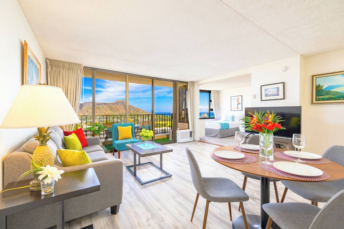 Une chambre d’hôtel moderne dotée d’un balcon, d’un coin repas et d’un salon.