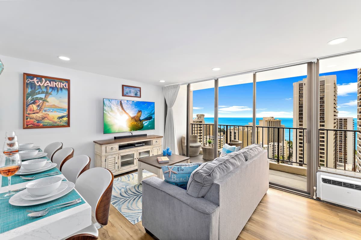A modern living room with a balcony, large windows, a dining area, and a TV.