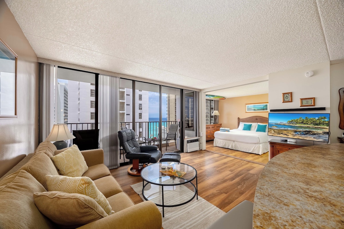 A modern living room with a sofa, armchairs, a coffee table, and a TV.