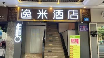 A hotel entrance with a staircase leading to the lobby.