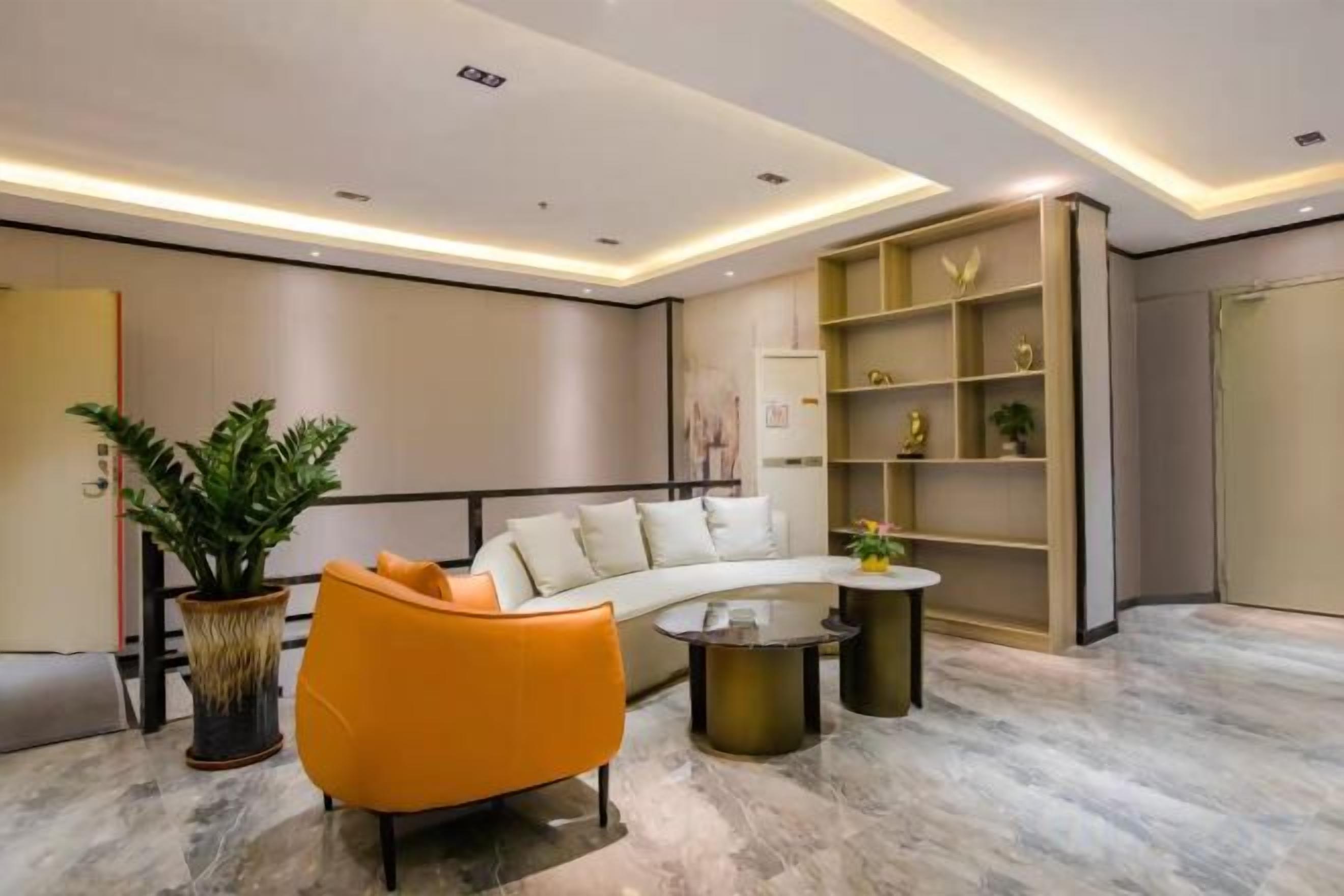 A modern living room with a curved sofa, a coffee table, and a potted plant.