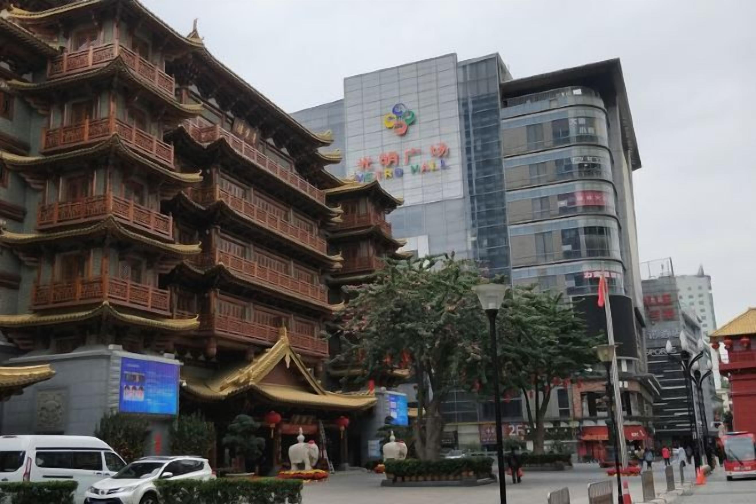 A traditional building with multiple balconies and a modern building with a sign in the background.