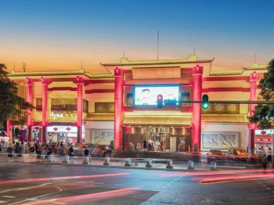 A building with a traditional architectural style, featuring a large entrance and a prominent digital billboard.
