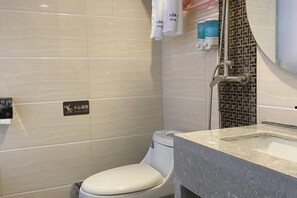 A bathroom with a toilet, a sink, and a shower. There are towels hanging on the wall and a sign indicating a baby changing area. - Yimi Hotel (Tianhe City branch of Guangzhou Beijing Road subway station) (Guangzhou)