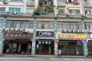 A multi-story building with various storefronts, including a hotel and a restaurant.