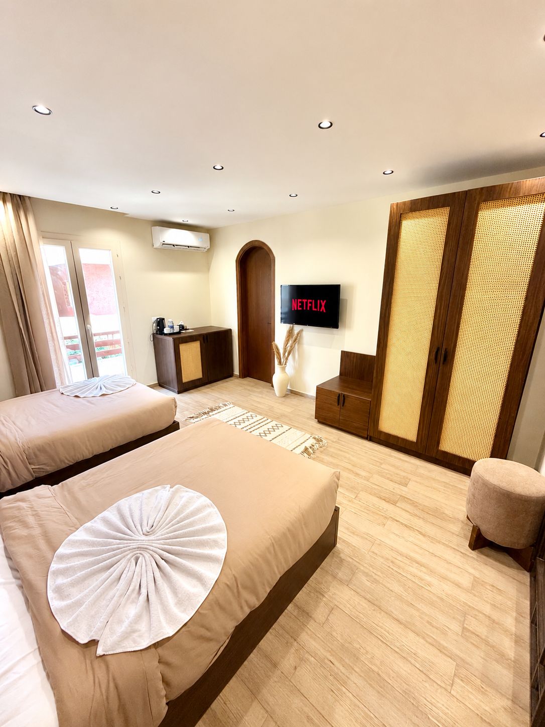 Habitació d'hotel amb dos llits, una televisió, un armari i un escriptori.
