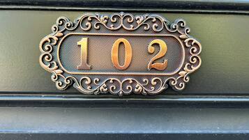 Une plaque de numéro de maison ornée de motifs métalliques travaillés.