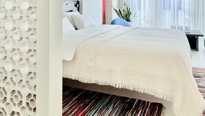 Un dormitorio moderno con una cama grande, un techo decorativo y vistas al exterior.