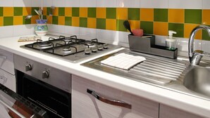 A modern kitchen with a gas stove, oven, and stainless steel sink.