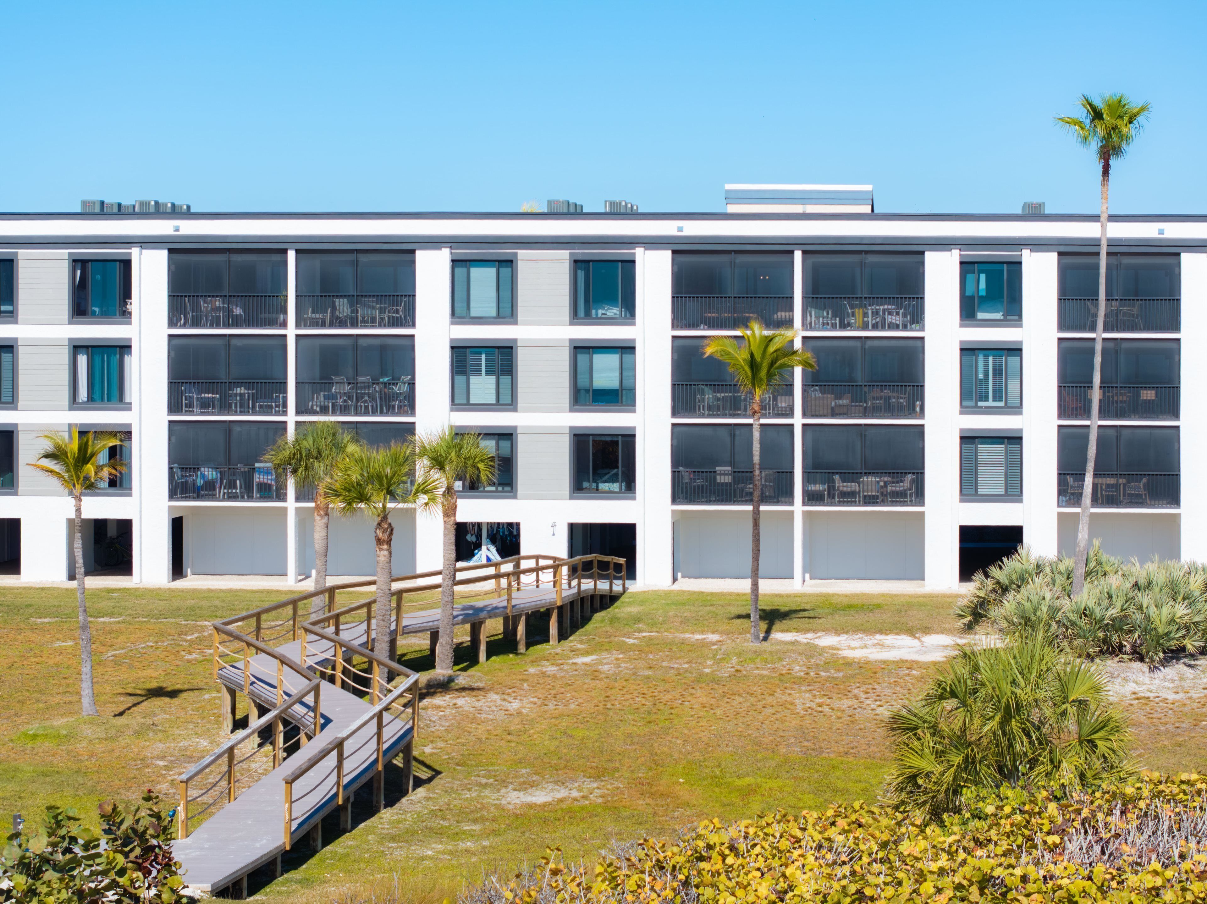 A modern building with multiple floors, large windows, and a covered walkway.