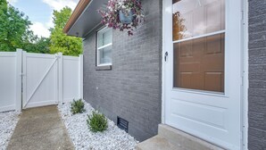 A residential house with a white garage door, a grey brick exterior, and a white picket fence. - Dayton Condo w/ Courtyard < 3 to Downtown! (Dayton)