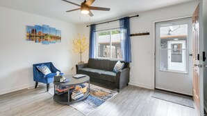 A living room with a sofa, armchair, coffee table, and artwork on the wall. - Dayton Condo w/ Courtyard < 3 to Downtown! (Dayton)