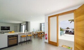 A modern kitchen with a dining area, a fire extinguisher, and a view of the outdoors.