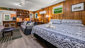 A cozy room with a bed, a desk, a chair, a bookshelf, and a window with a view. - Charming Serene Cabin in Nantahala Gorge near Bryson City (Bryson City)