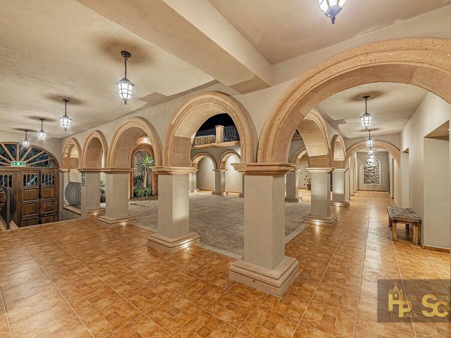 Un interior amplio con techos altos, columnas en arco y suelo de baldosas.