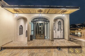 A hotel entrance with a covered walkway, a glass door, and a decorative gate. - Casa Cristal, Hotel Boutique (San Miguel de Allende)
