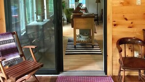 A wooden interior with a sliding glass door leading to a dining area.