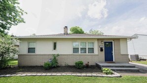 A single-story house with a blue front door, a small porch, and a brick foundation. - Game Room|Chef Kitchen|Dogs OK|1 mi to downtown GC (Grove City)