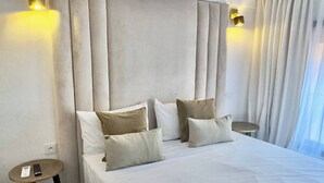 A hotel room with a large bed, two bedside tables, and a headboard with built-in lighting. - Luxury Duplex -Marrakech Centre (Marrakech)