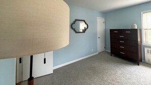 Ein Zimmer mit einer großen Lampe, einem Schminktisch, einem Spiegel und einer Tür.