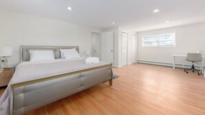 Une chambre moderne avec un grand lit, un bureau et une chaise.