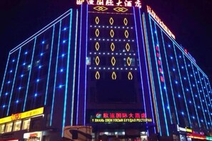 A multi-story building with illuminated signage and windows, likely a hotel or commercial building.