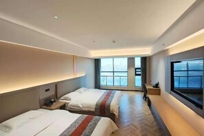 A hotel room with two beds, a large window, a TV, and a desk. - Oulian International Hotel (Erenhot)