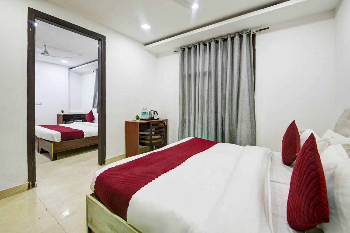 Habitación de hotel con una cama grande, una mesita de noche de madera, un espejo y un armario.