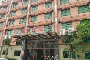 A multi-story hotel with a prominent entrance and a covered area. - Yuelaite Junyi Hotel (Sanya)