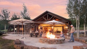 Eine rustikale Lodge mit einem Steinkamin und Sitzgelegenheiten im Freien.