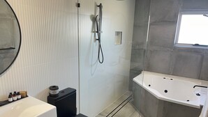 A modern bathroom with a white sink, black toilet, and a freestanding bathtub.
