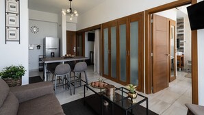 Een moderne woonkamer met een bank, een salontafel en een eethoek met stoelen.