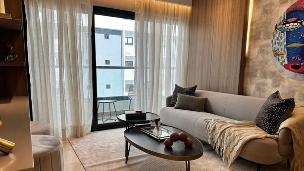 Ein modernes Wohnzimmer mit Sofa, Couchtisch und Blick auf den Balkon.