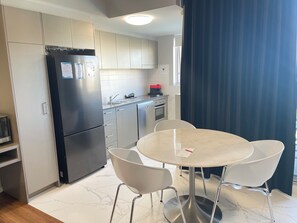 Enjoy meals in this well-equipped kitchen with a dining table for two, a kitchen island, and a refrigerator.