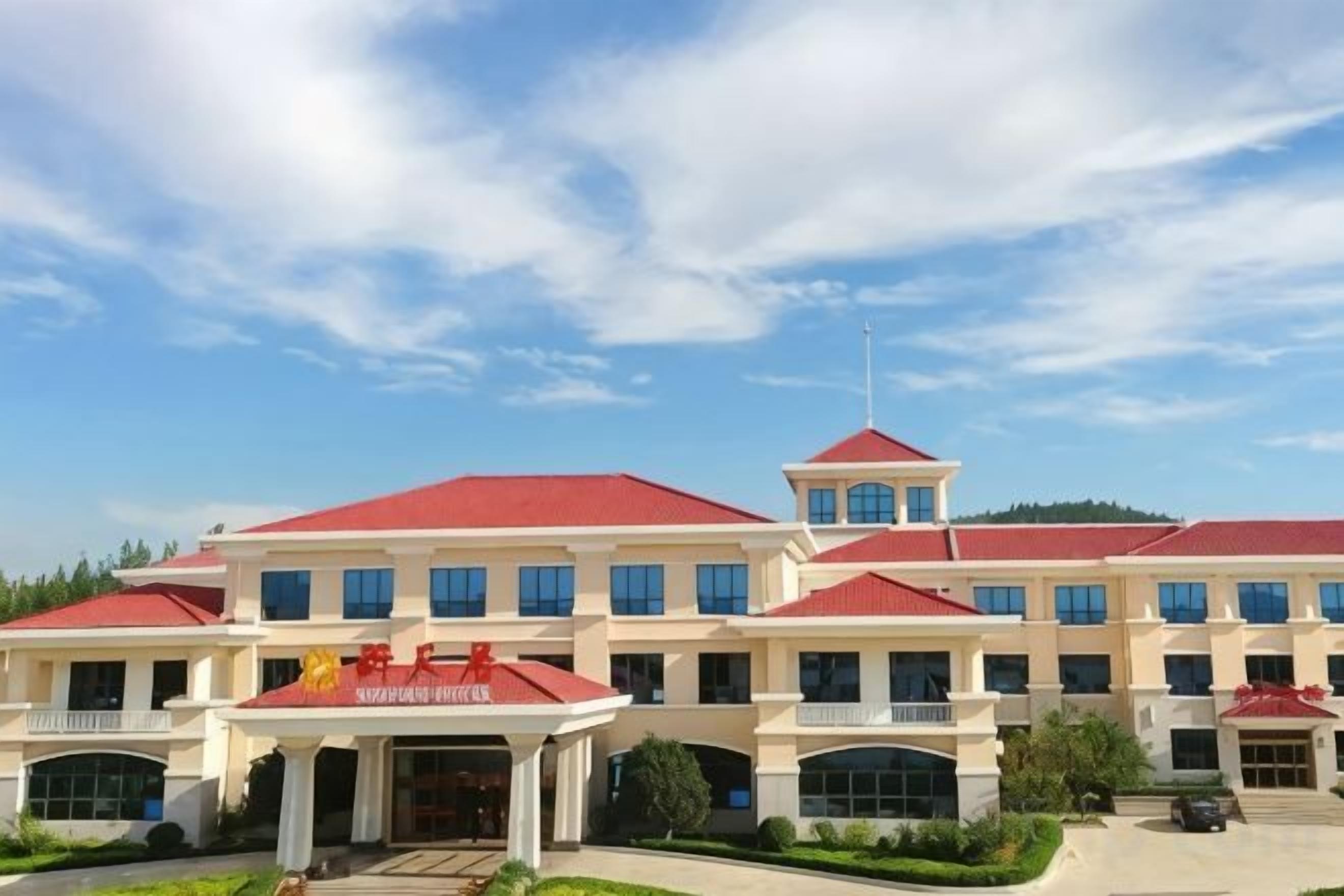 A multi-story hotel with a red roof and a central tower.