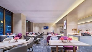 A modern hotel lobby with marble flooring, multiple seating areas, a reception desk, and a digital display on the wall. - Lavande Hotel Shenzhen Longgang Dayun Center Jixiang Metro Station (Shenzhen)