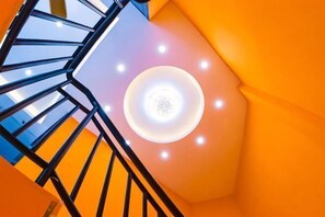Una escalera de caracol con un accesorio de luz circular en la parte superior.
