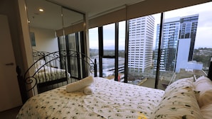 A hotel room with a bed, a window with a city view, and a balcony. - 2bd 2bth - Chic Apt in Woden CBD (Phillip)