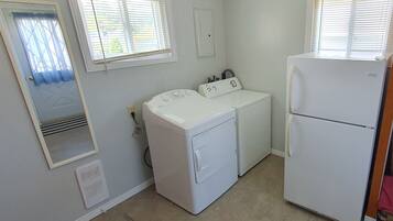 A laundry room with a washer, dryer, and refrigerator.