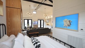 Ein modernes Schlafzimmer mit Bett, einer Couch und einem Essbereich.
