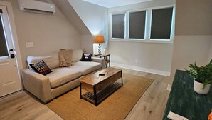Un salon avec un canapé, une table basse et un ventilateur de plafond.