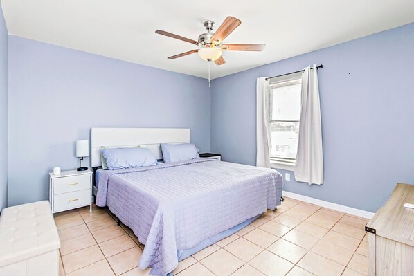 A bedroom with a bed, nightstand, lamp, and ceiling fan. - ♥︎Spacious 3BR Home Near SPI Beach & Restaurants♡ (Port Isabel)