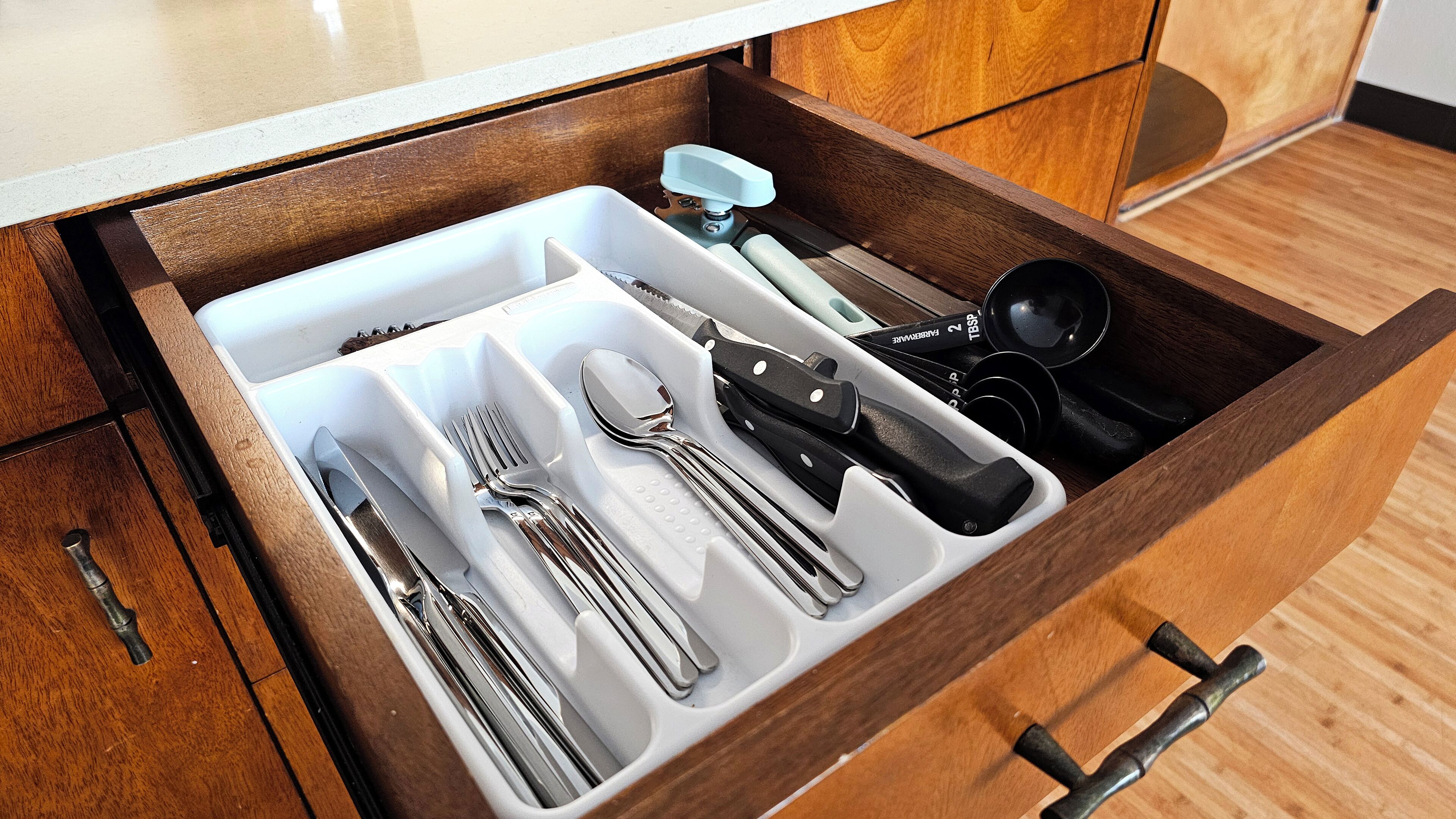 Uma gaveta com utensílios organizados.