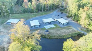 A lodge with four cabins, a central building, and a small dock by a lake. - Golden Pond Cabins (Altmar)