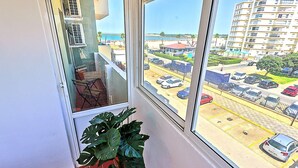 Un balcón con vista a un estacionamiento y una playa.