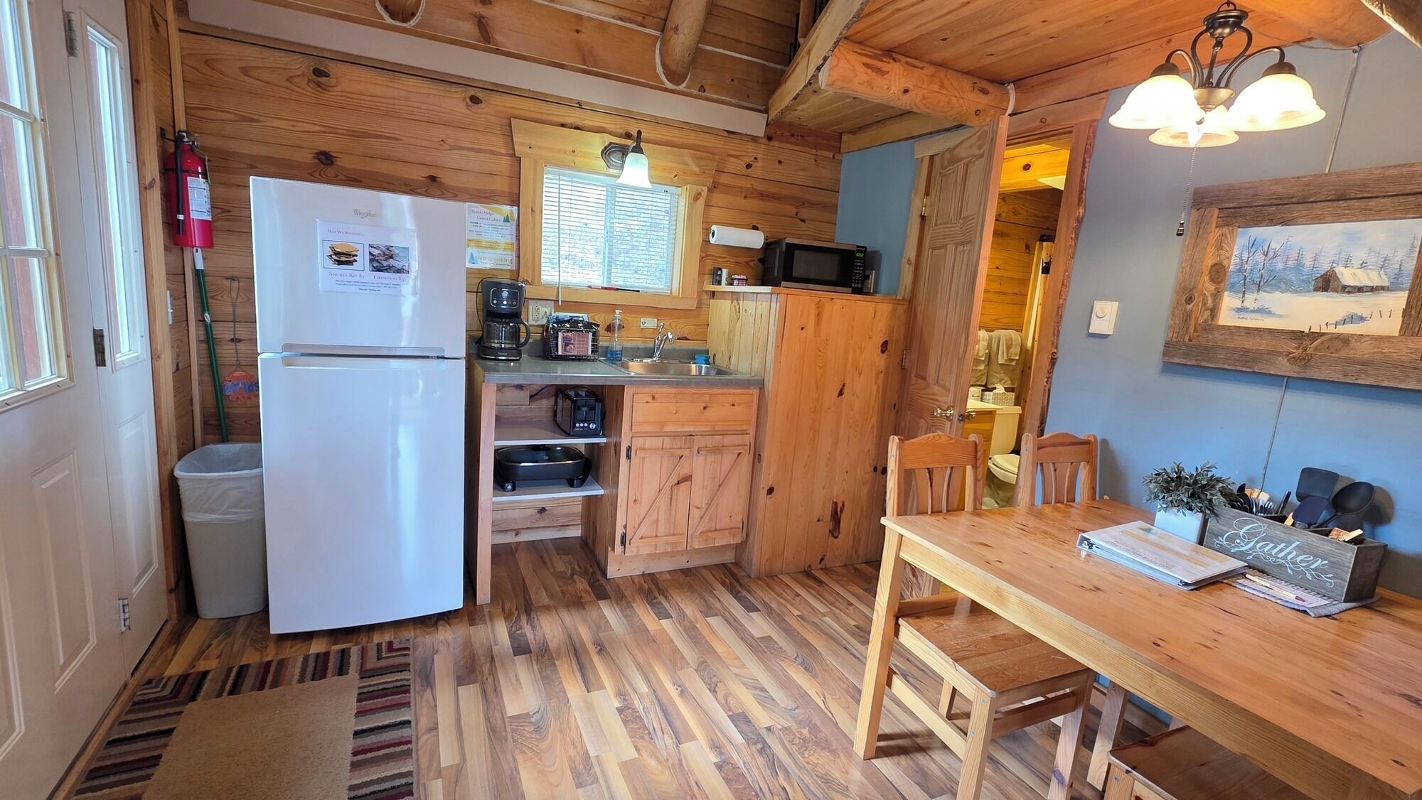 A compact kitchen with a refrigerator, microwave, and wooden cabinets.