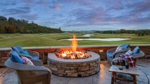A stone fire pit with a view of a golf course. - 2 Bedroom Deluxe Suite in Great Smokies Lodge! (Sevierville)