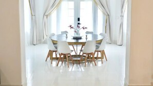 A dining area with a round table, six chairs, and a vase with flowers. - Spacious & Modern Pāhoa Retreat Near Kehena Beach! (Pahoa)