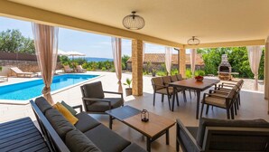 A covered outdoor area with a pool, seating, and a barbecue. - Villa Loni with Pool & Seaview (Bajčići (Krk))